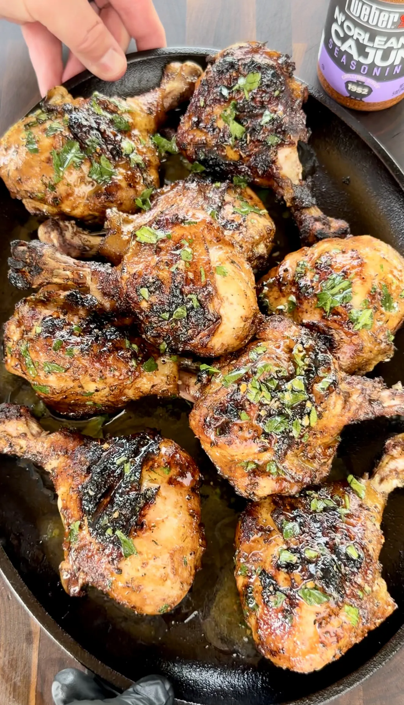Grilled chicken drumsticks with Cajun honey butter glaze piled in a cast iron skillet