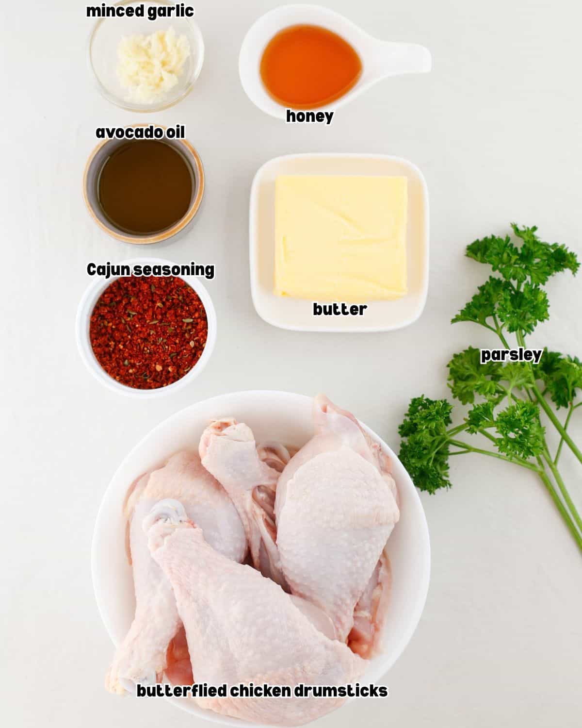 bowls of ingredients for cajun grilled chicken drumsticks placed on a kitchen countertop.