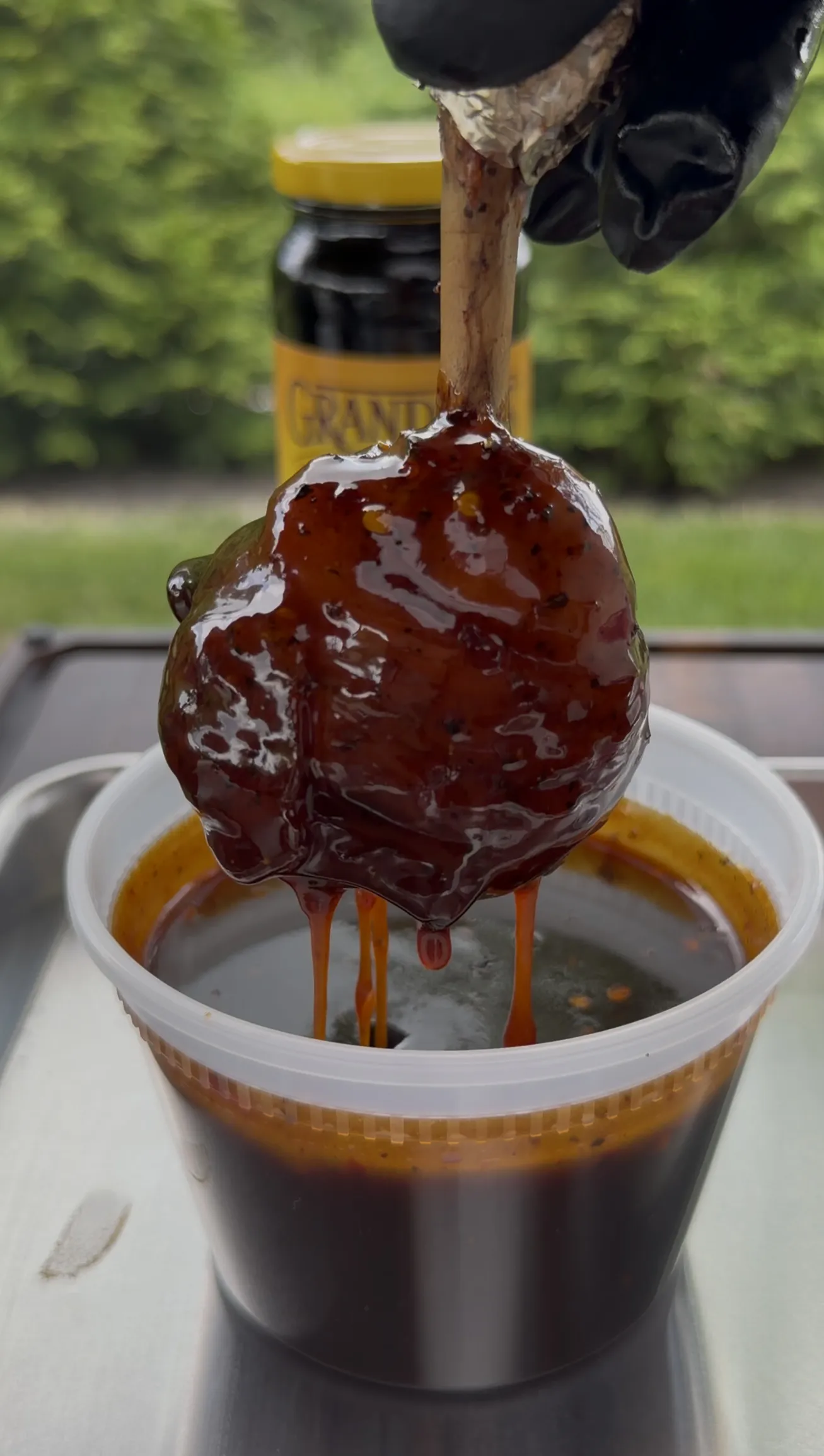 Molasses glazed bacon wrapped chicken lollipop with a glossy candied coating