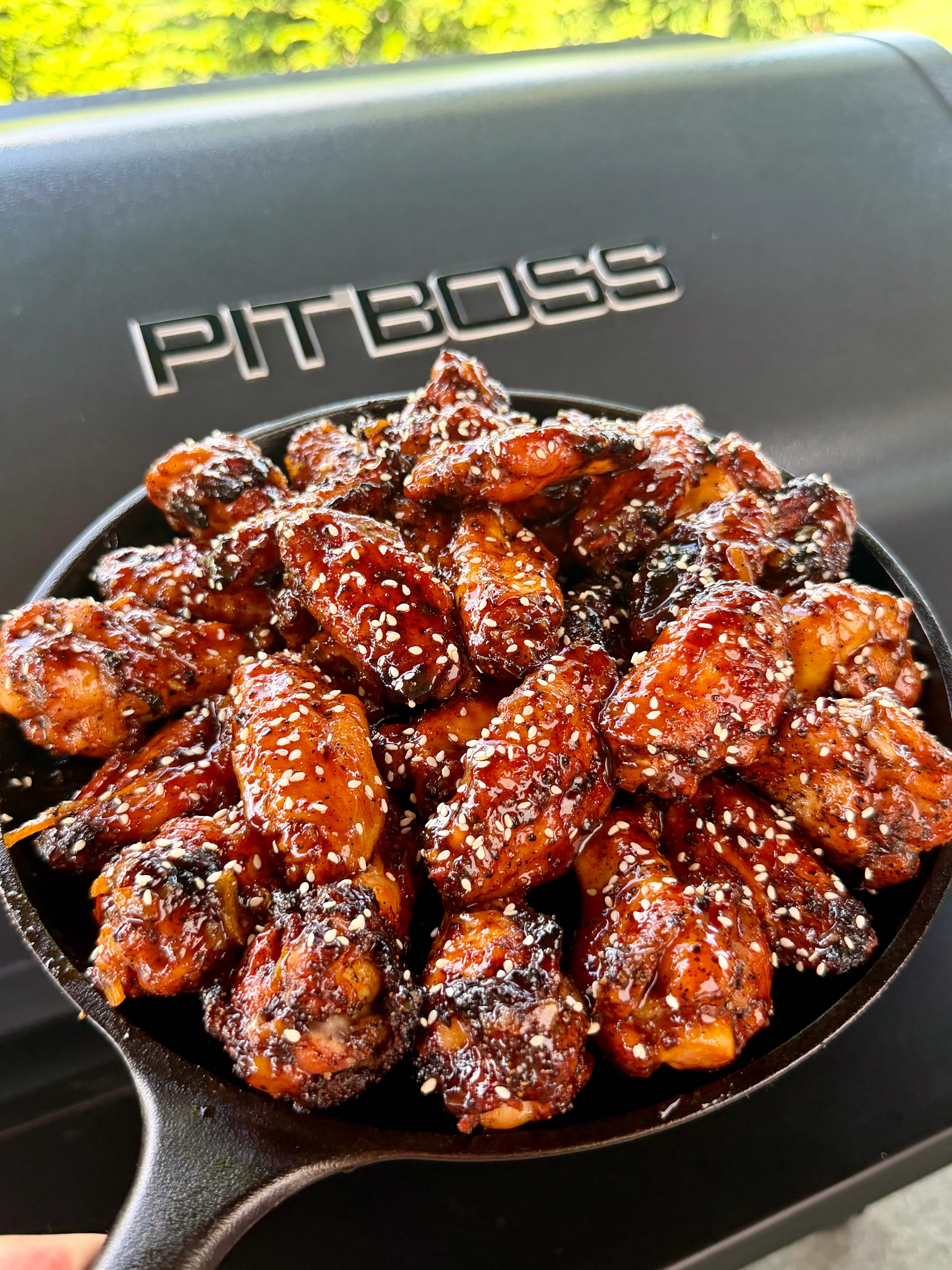Finished wings with sesame seeds served hot in a cast iron skillet