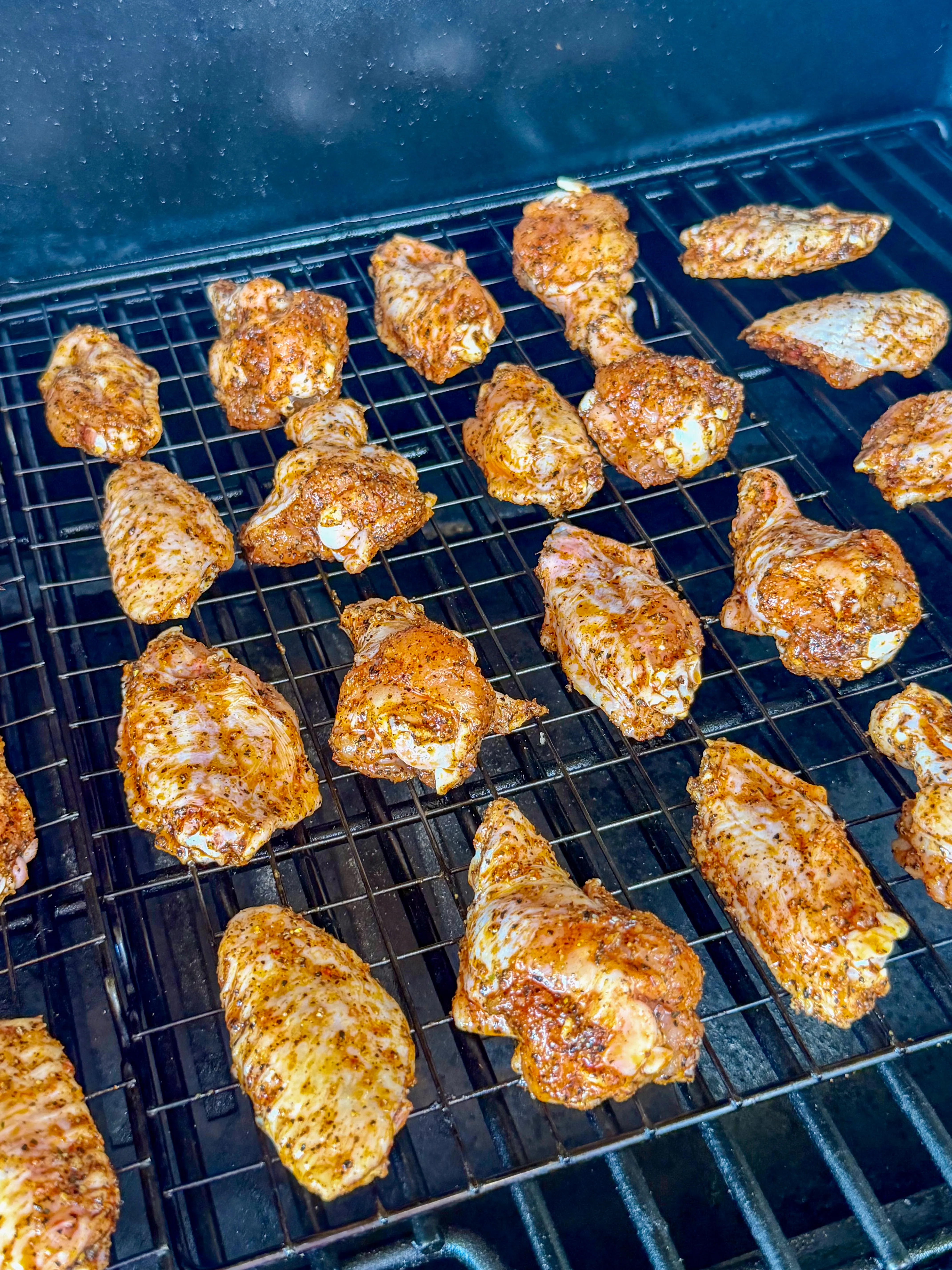Wings on a wire rack inside the smoker during the hot 400 degree cook