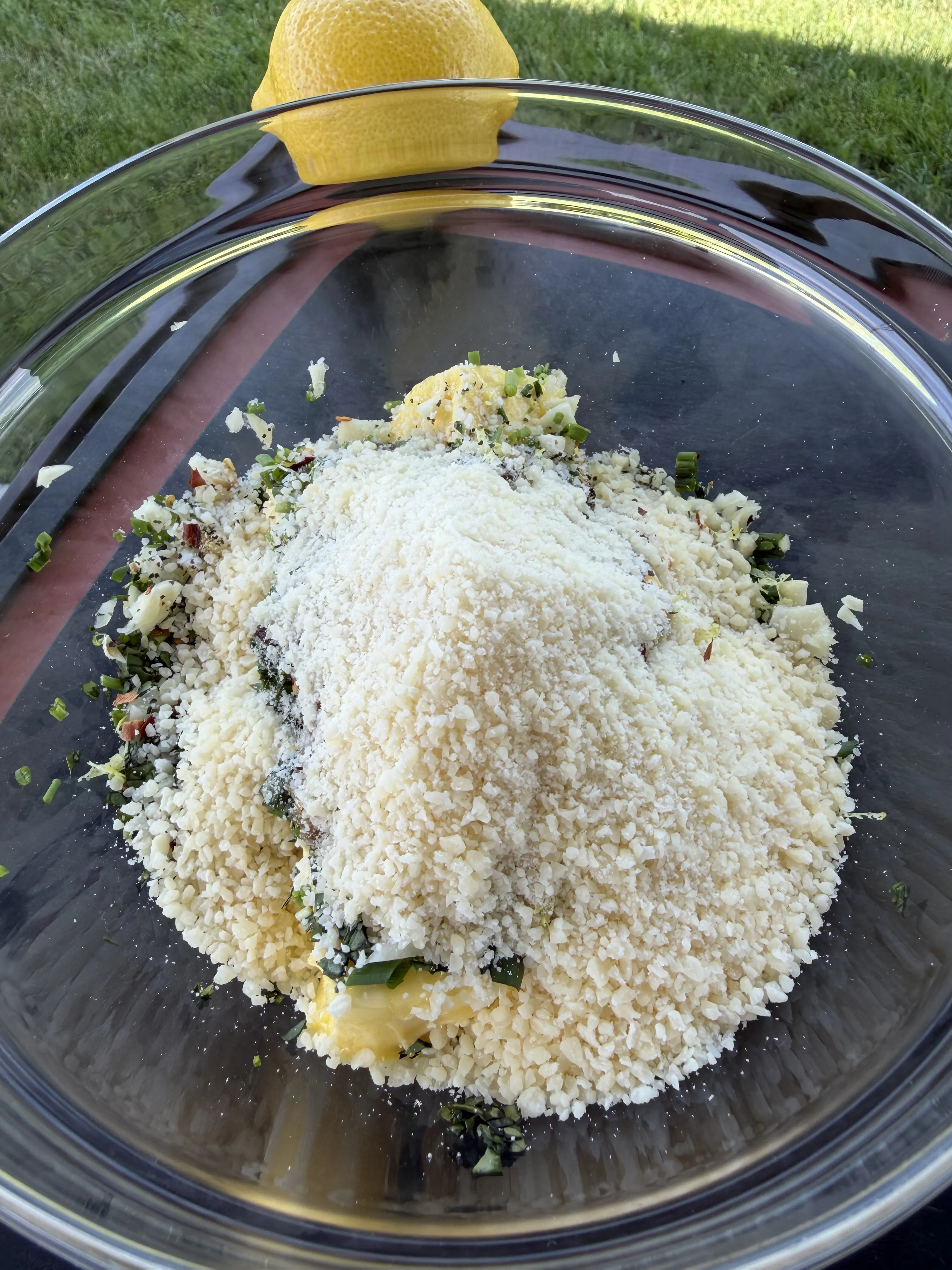 Grated Parmesan, fresh herbs, and softened butter coming together in a mixing bowl