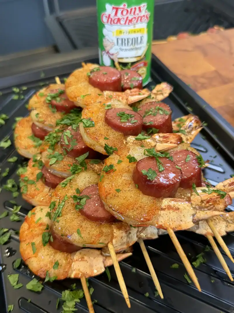 Grilled shrimp and sausage skewers seasoned with Tony Chachere's Creole seasoning, garnished with fresh parsley