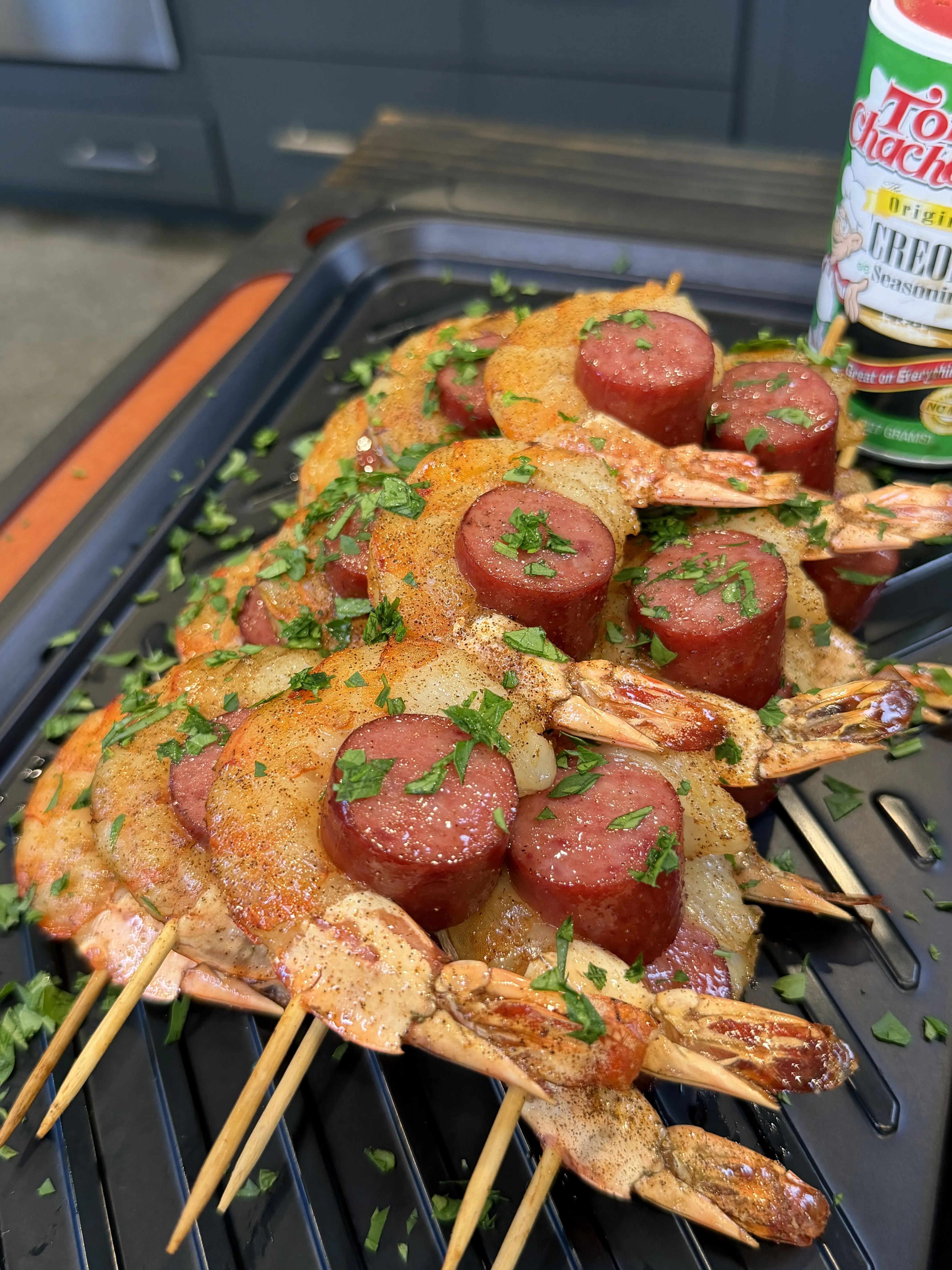 Grilled smoked shrimp and sausage skewers seasoned with Tony Chachere's Creole seasoning, topped with fresh parsley