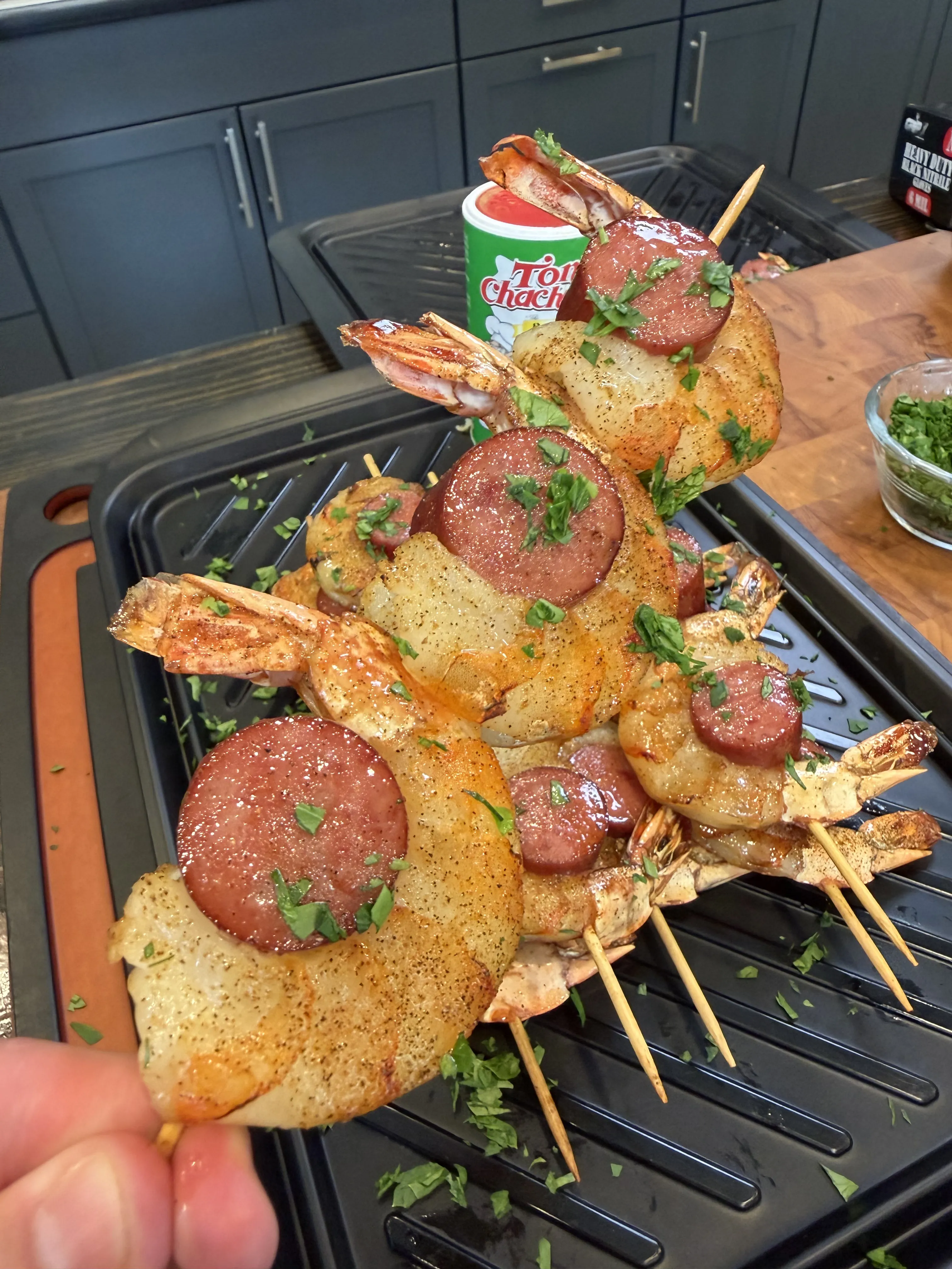 Smoked shrimp and sausage skewers topped with fresh herbs, ready to serve