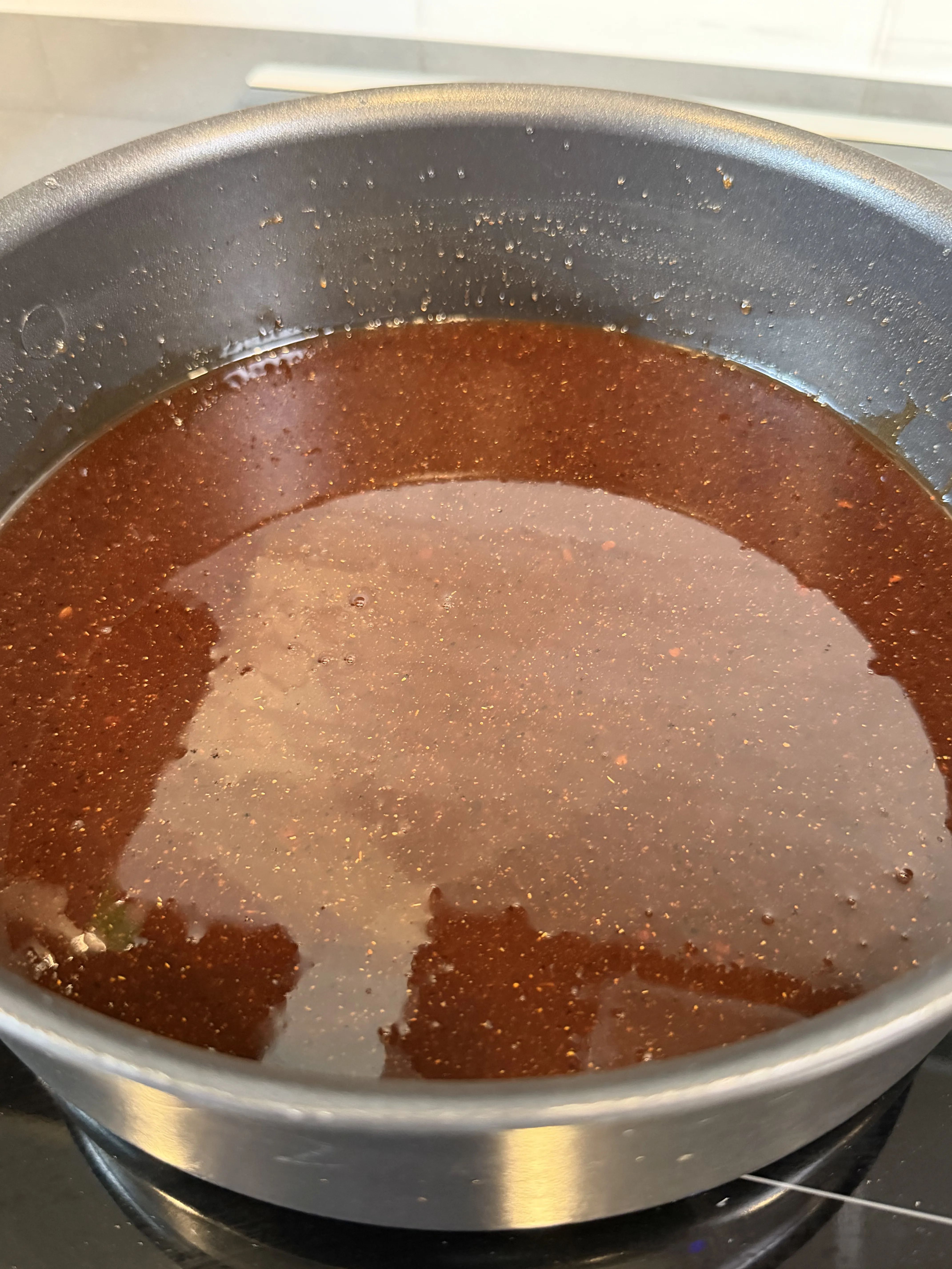BBQ sauce warming in a pan before glazing the onion bombs
