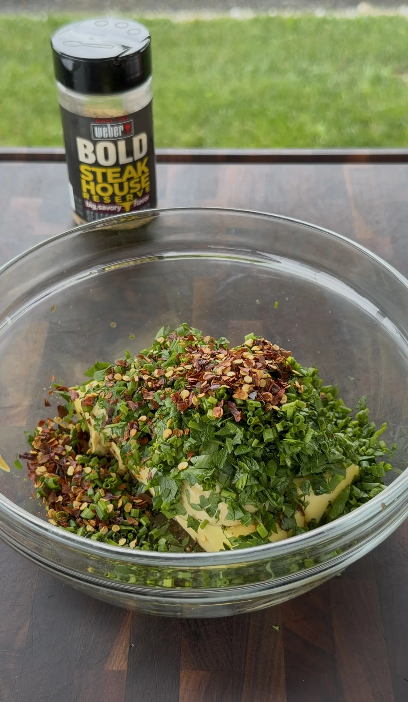Compound butter ingredients coming together in a glass mixing bowl