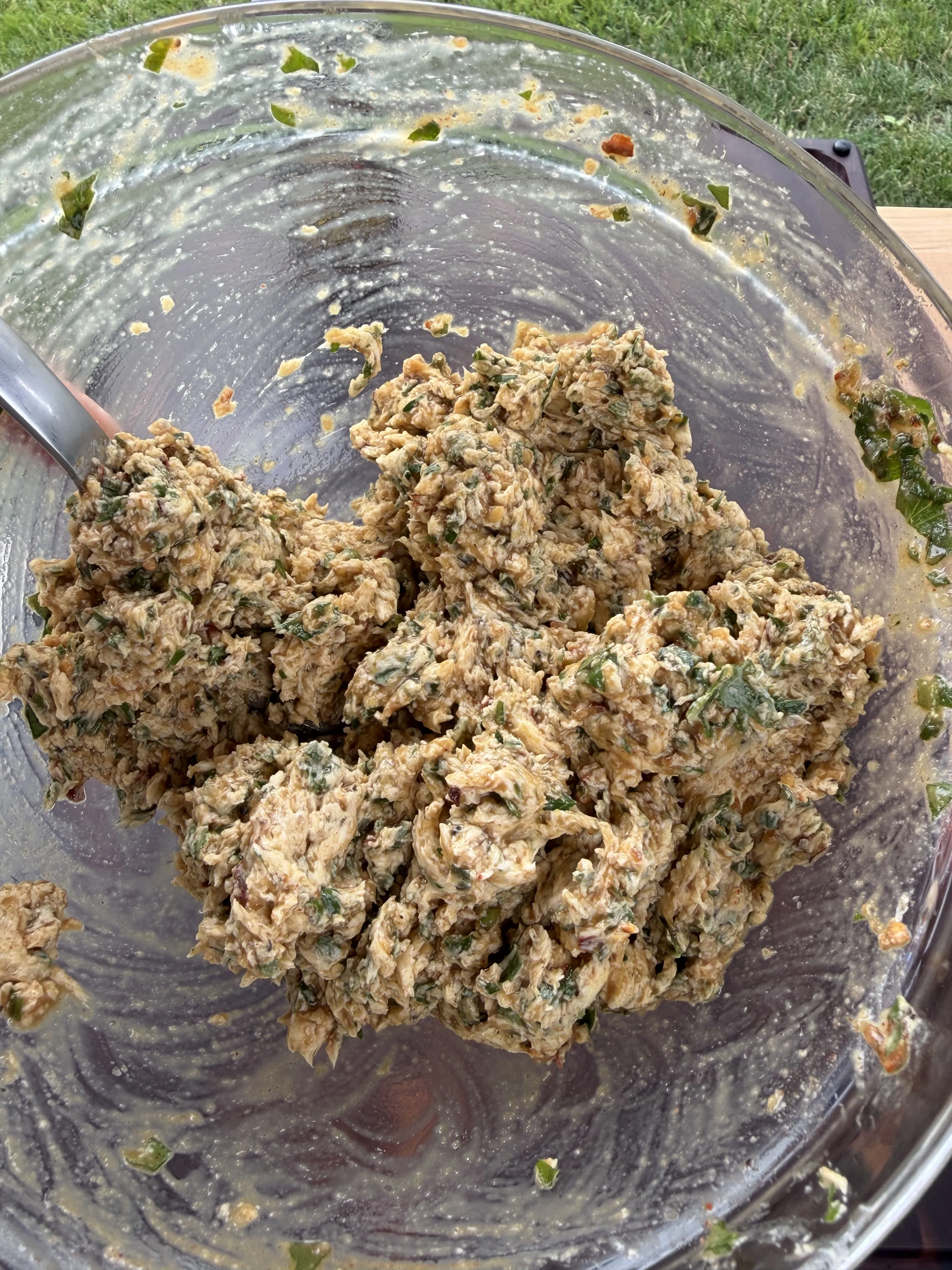 Herb compound butter mixture fully combined in a stainless steel mixing bowl