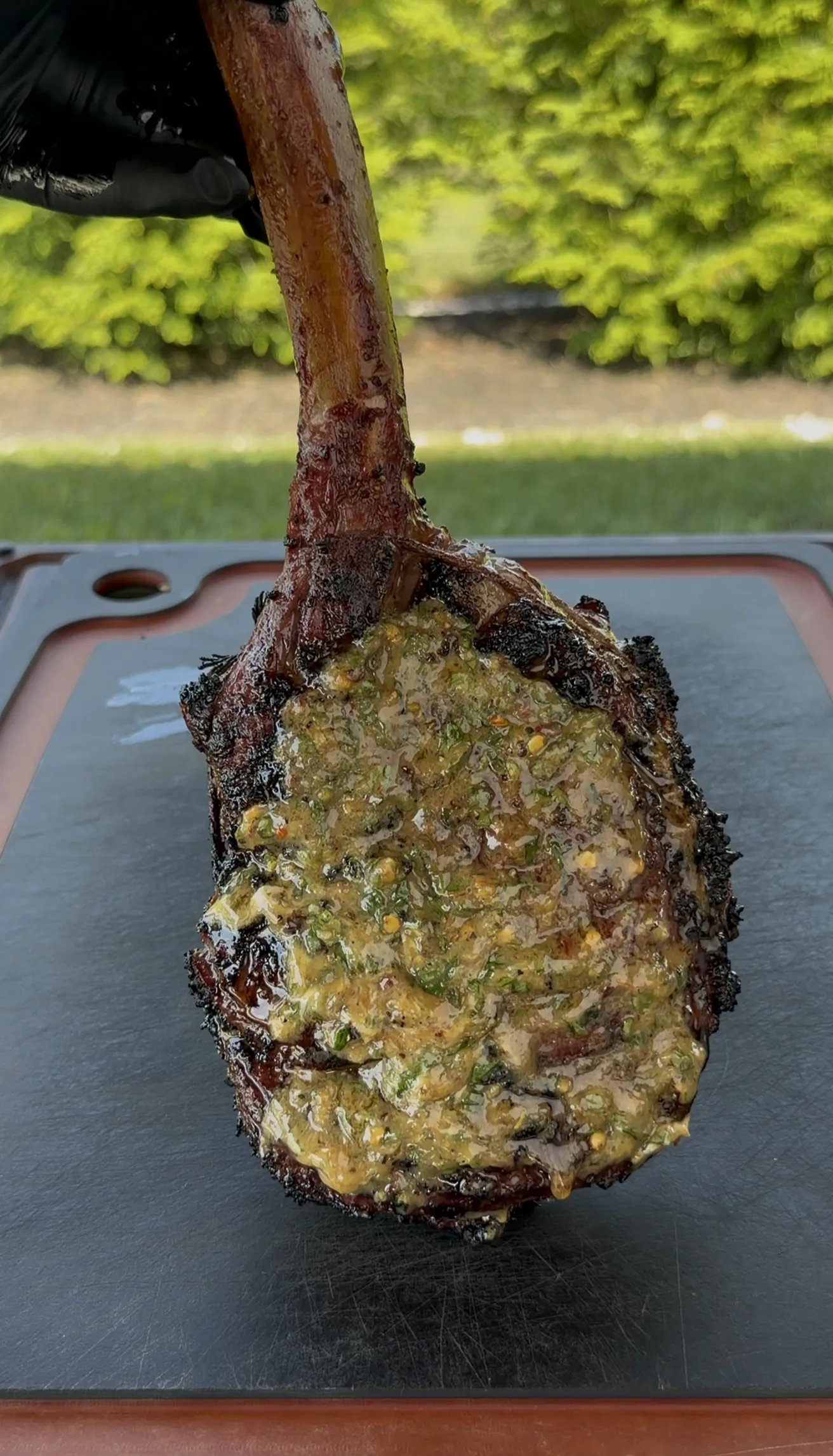 Grilled tomahawk ribeye topped with a melting round of herb compound butter