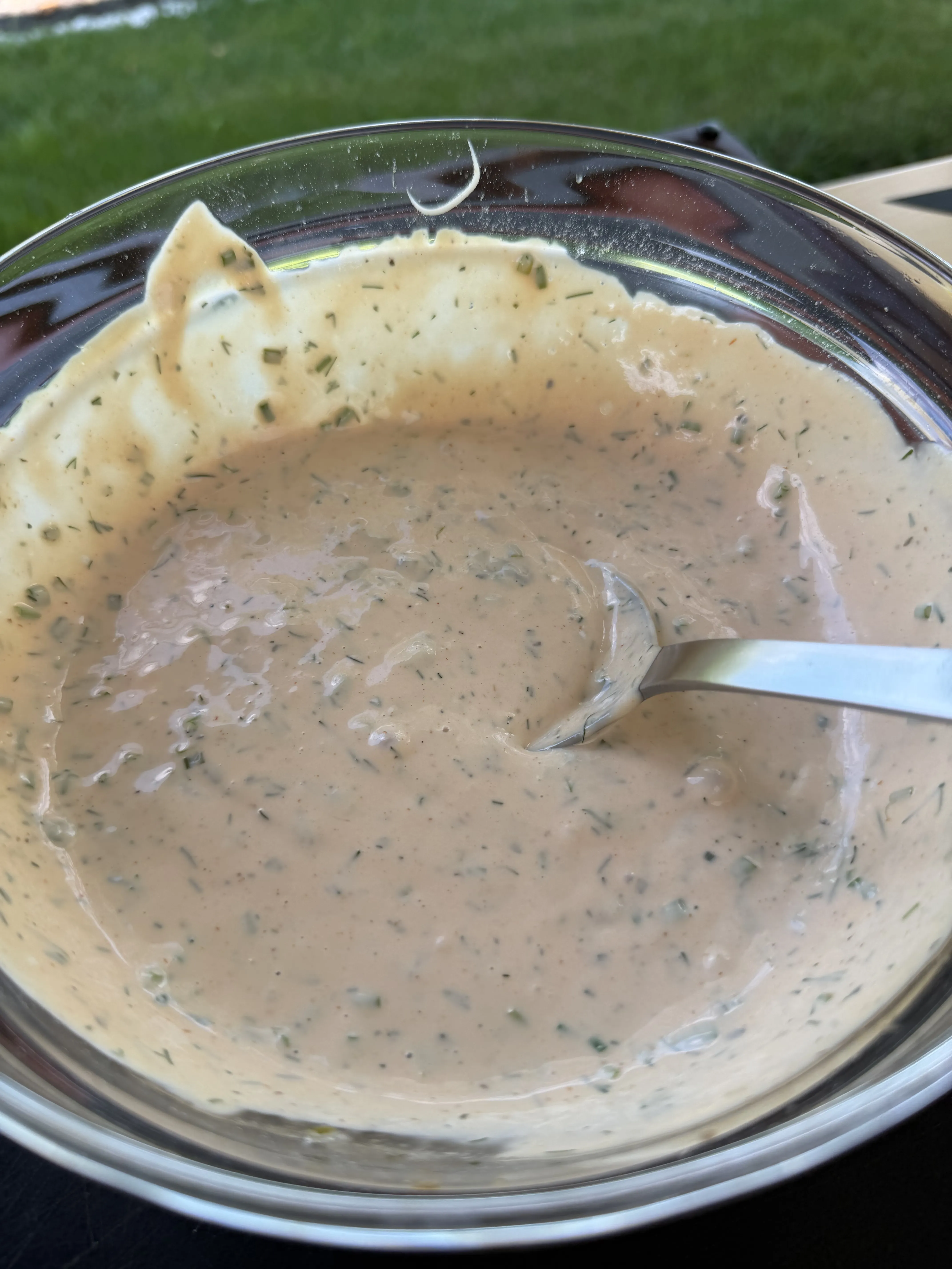 Creamy homemade burger sauce with fresh dill and herbs in a glass bowl