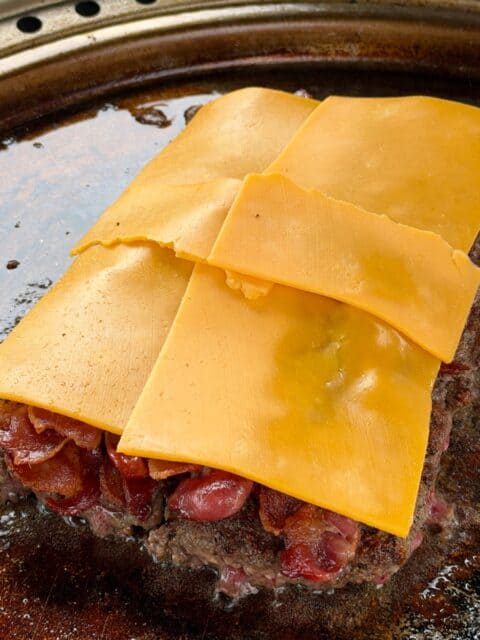 Large griddle-seared beef patty topped with crispy bacon and sharp cheddar for bacon cheeseburger sliders