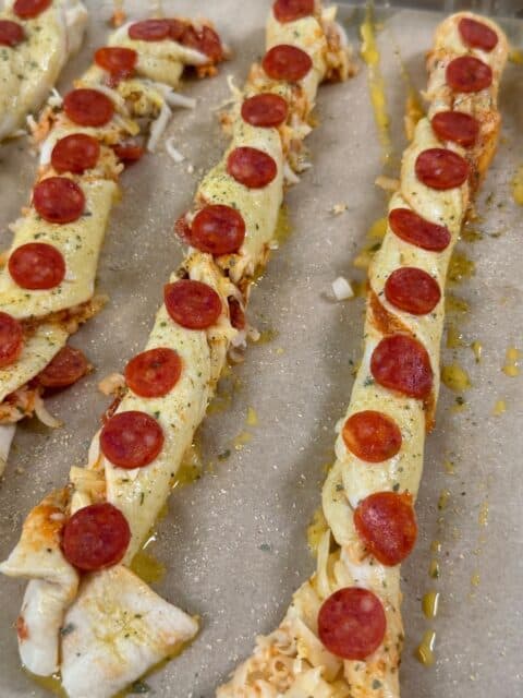 Pizza twists brushed with egg wash and topped with mini pepperoni, Parmesan, and Italian seasoning