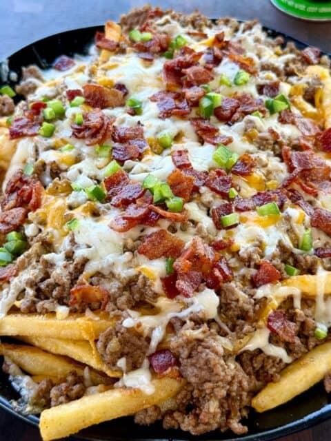 Bacon Cheeseburger Loaded Fries finished with melted cheese, crispy bacon and diced jalapeños