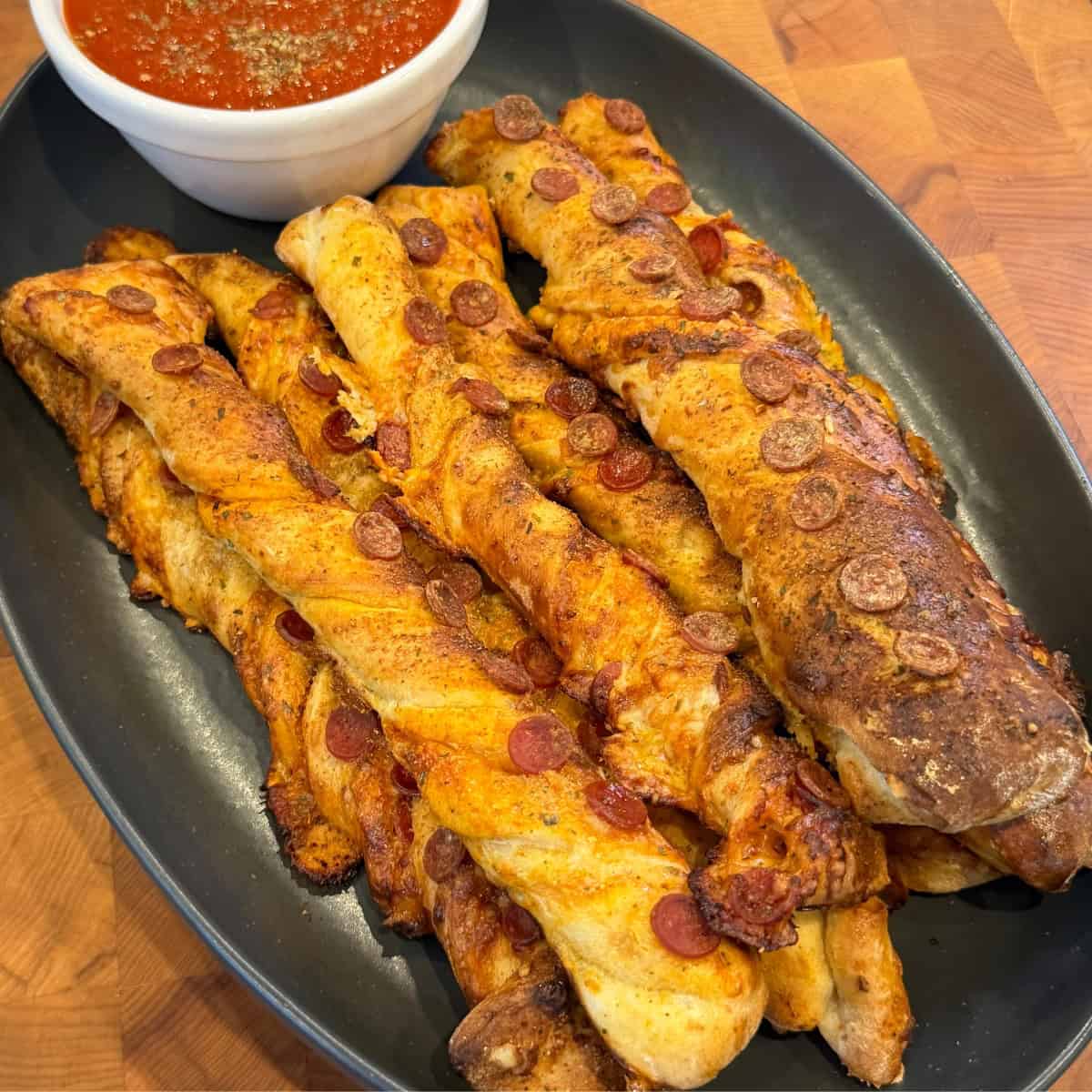 Pellet smoked pizza breadsticks topped with mini pepperoni and served wth pizza sauce for dipping