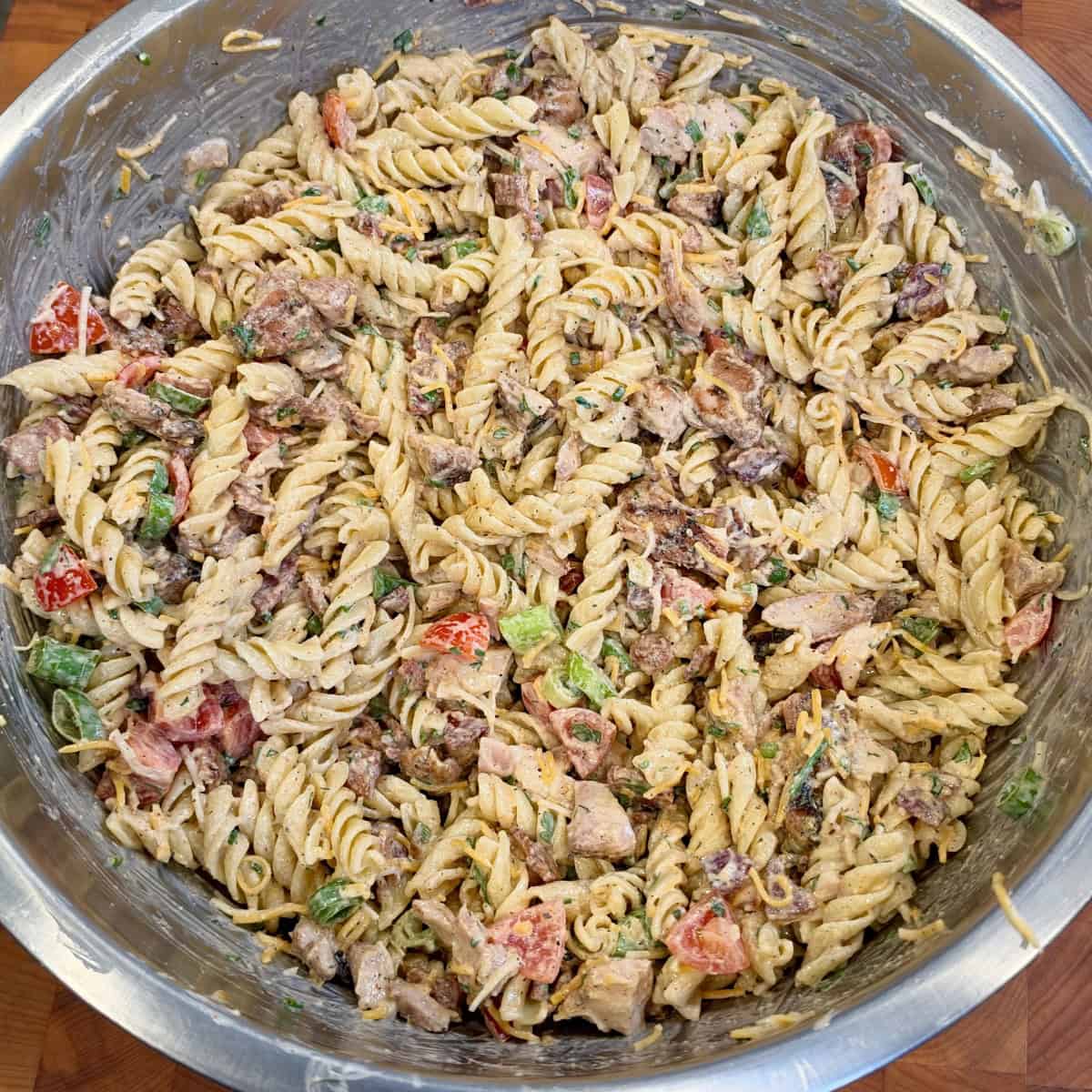 Chicken Bacon Ranch Pasta Salad with grilled chicken, crispy bacon, Monterey Jack and cheddar cheese, tomatoes, and homemade ranch dressing