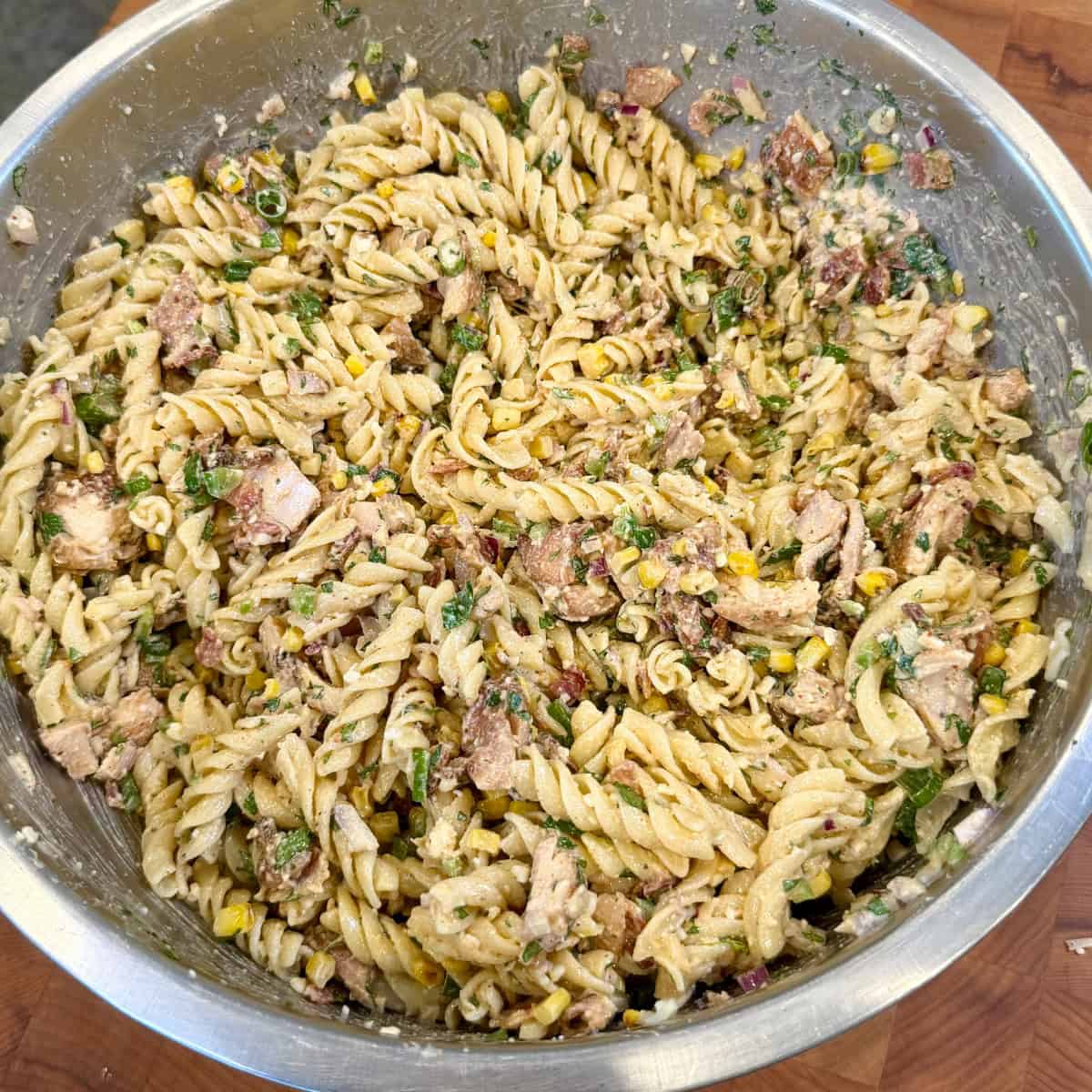 street corn pasta salad with grilled chicken, charred corn, bacon, Cotija cheese, and rotini pasta
