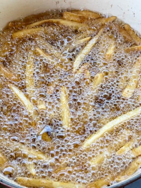 Frozen French fries frying at 350°F in small batches for Bacon Cheeseburger Loaded Fries