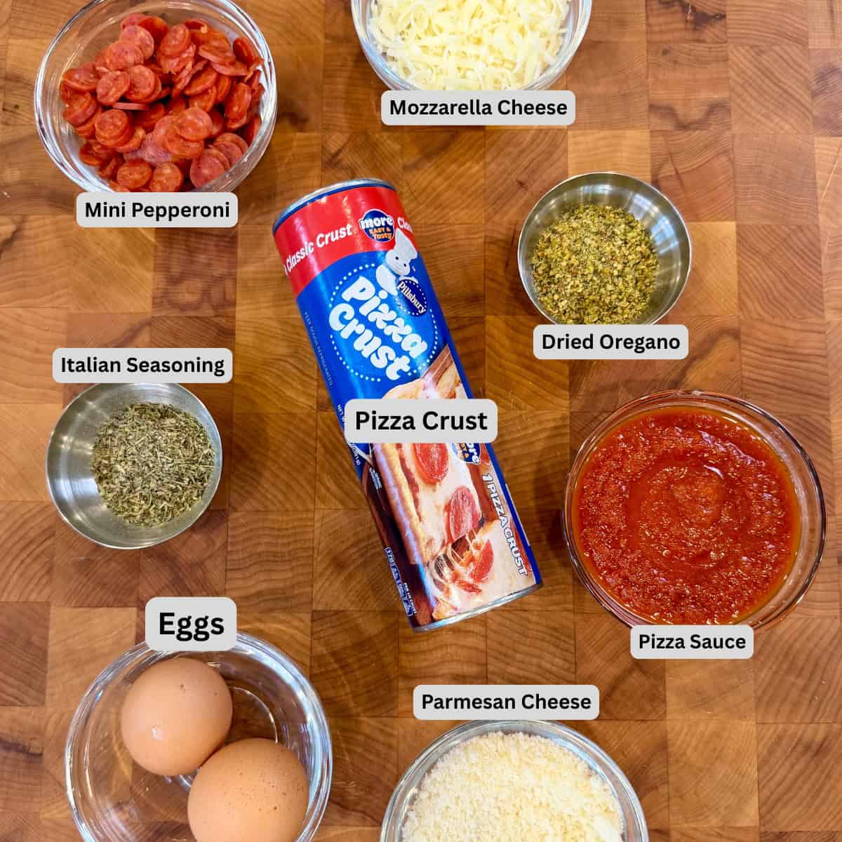 Labeled ingredients for Pellet Smoked Pizza Breadsticks including pizza dough, mozzarella, Parmesan, mini pepperoni, pizza sauce, egg, and seasoning