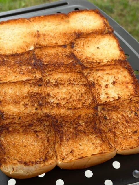 Hawaiian slider rolls toasted golden brown on the griddle for bacon cheeseburger sliders