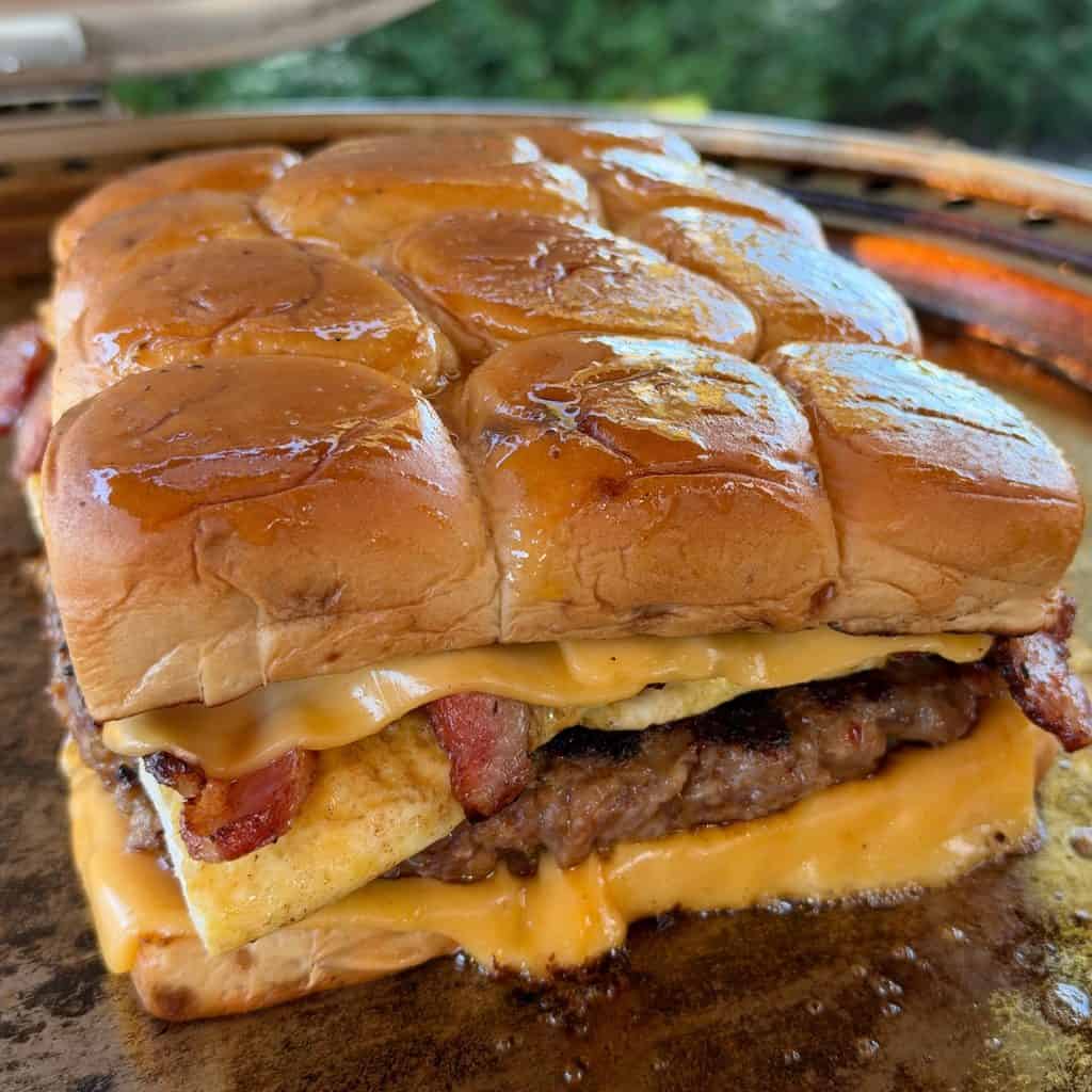 Easy Breakfast Sliders with sausage, folded eggs, crispy bacon, and melted American cheese on King's Hawaiian Maple Brown Sugar Rolls.
