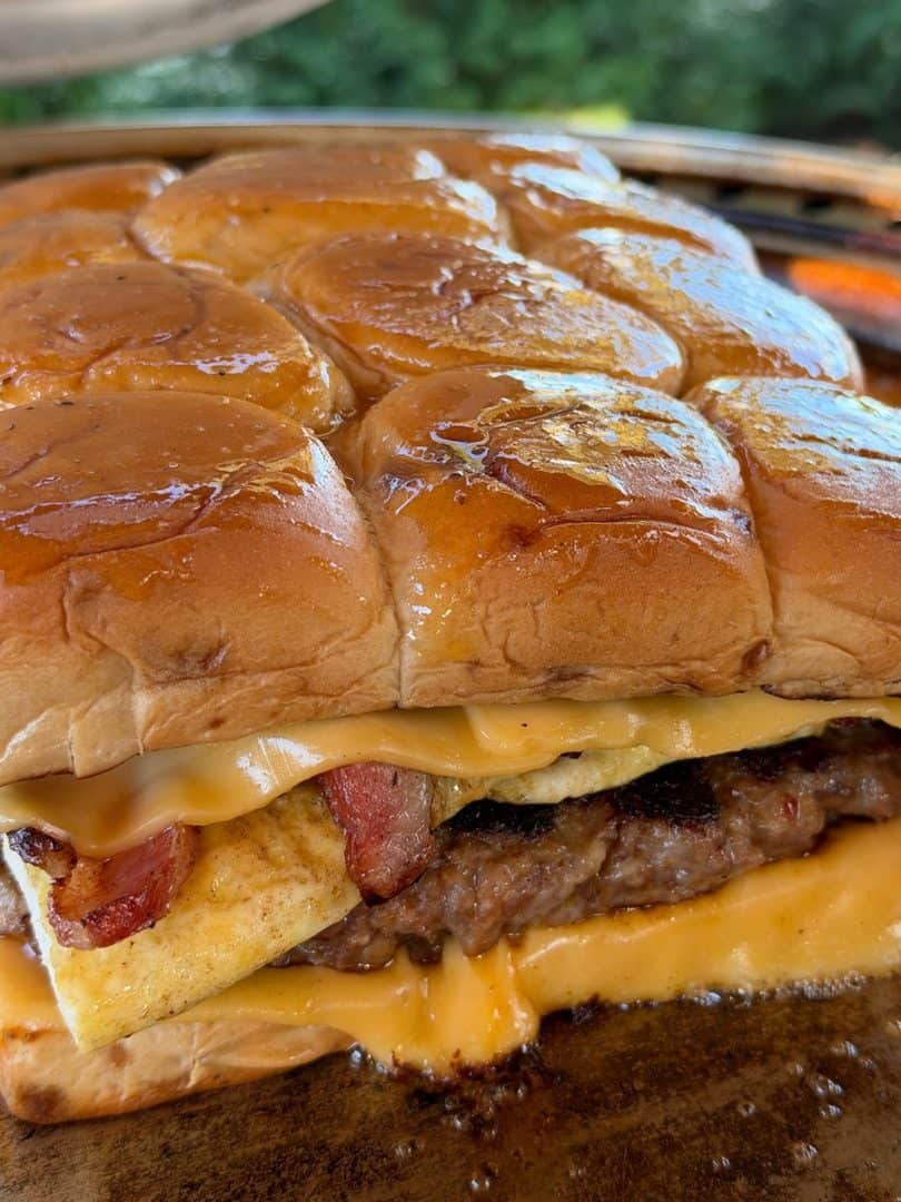 Easy Breakfast Sliders with sausage, folded eggs, crispy bacon, and melted American cheese on King's Hawaiian Maple Brown Sugar Rolls.