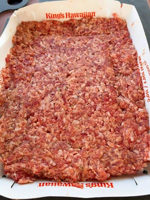 Breakfast sausage pressed into a King's Hawaiian roll tray to form one oversized rectangular patty for Easy Breakfast Sliders.