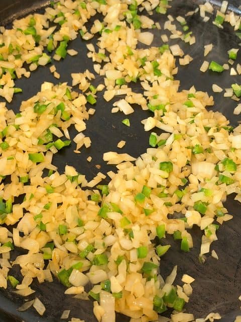 Diced yellow onion and jalapeño sautéing in rendered beef and chorizo fat in a Dutch oven for easy homemade chili.