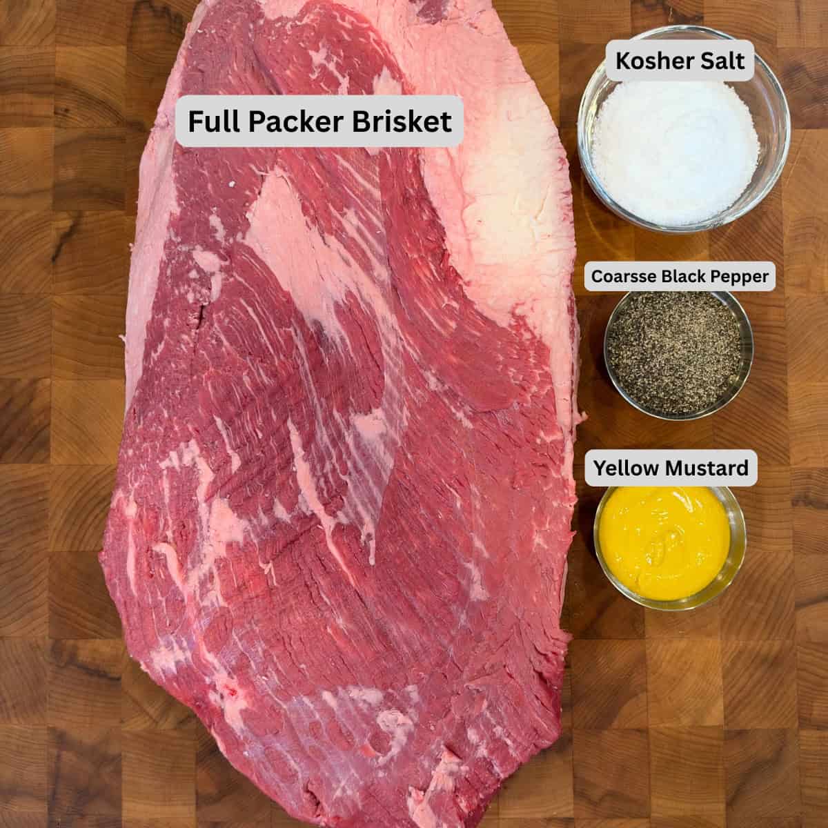 Whole packer beef brisket with kosher salt, coarse black pepper, and yellow mustard arranged for a Texas-style smoked brisket recipe.